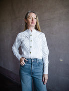 Image featuring a woman wearing the light Italian cotton cardigan sweater from Vince with an open knit in an intricate diamond motif and cut with a slightly cropped length in white.