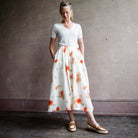 Image featuring a woman wearing the Vince Poppy midi-skirt in an abstract blurred poppy print and finished with a gathered waist and side-seam pockets.