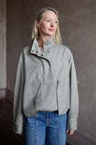 Mature model wearing a modern design light weight virgin wool gray jacket by We-AR4 with front pockets