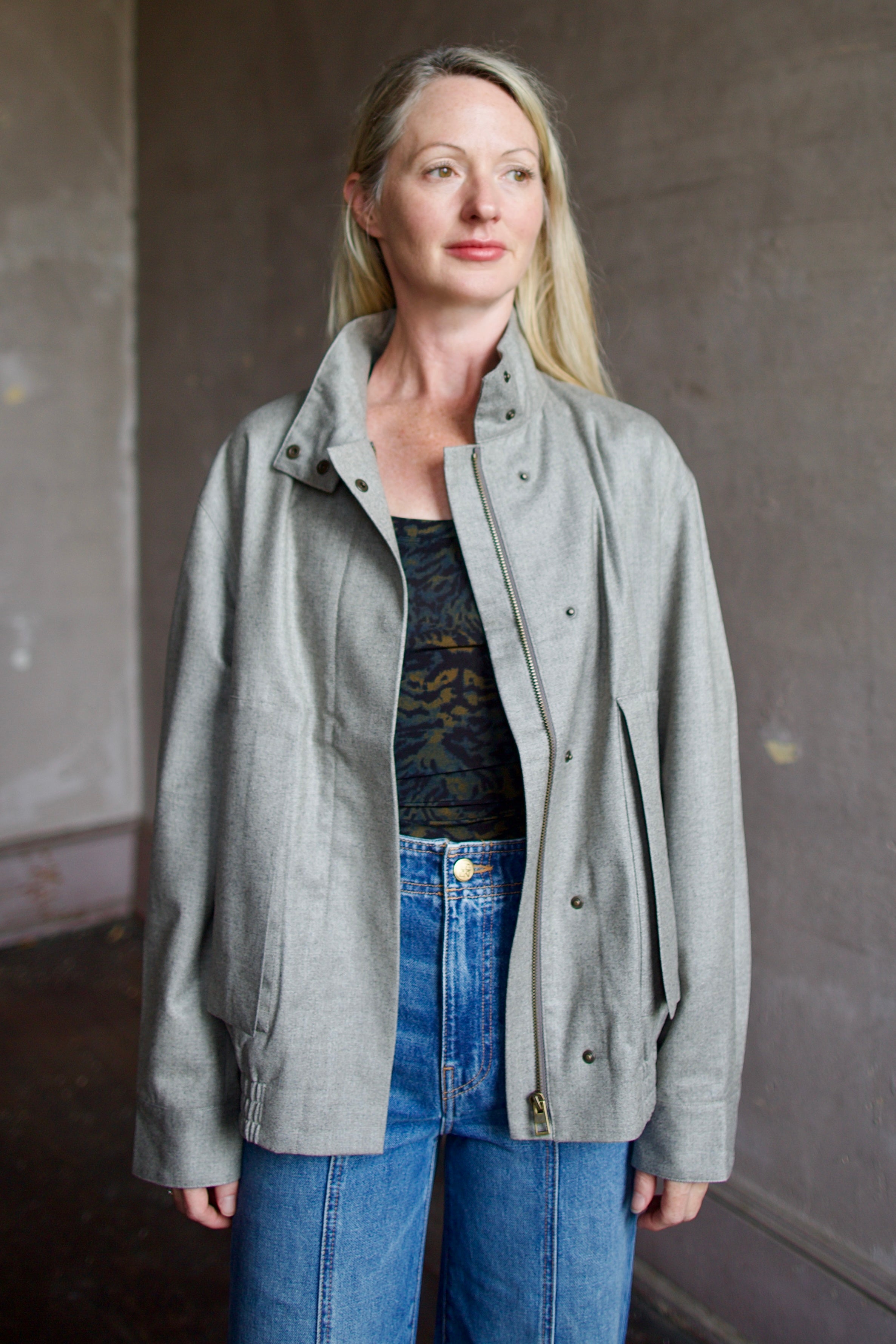 Mature model wearing a modern design light weight virgin wool gray jacket by We-AR4 with front pockets