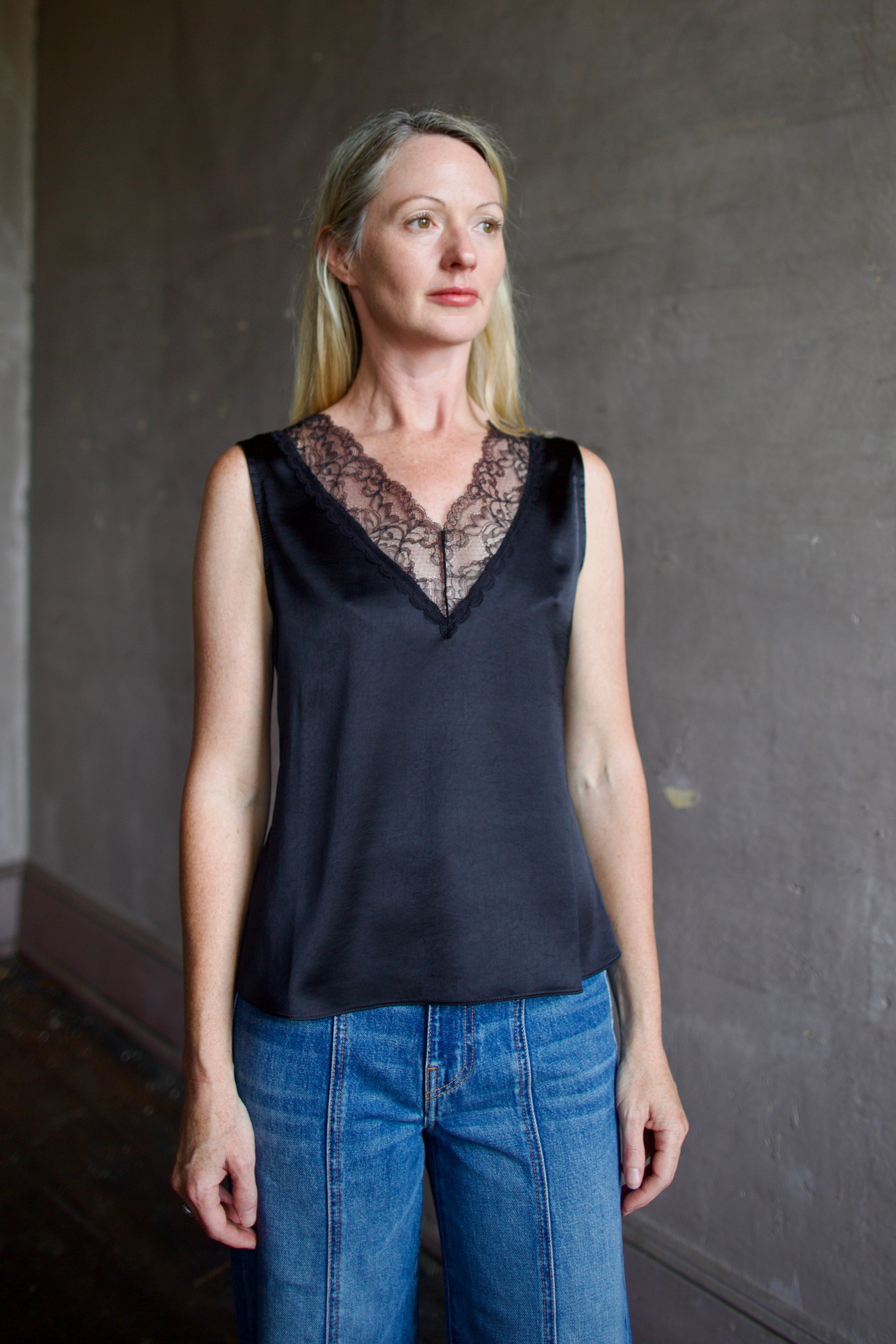 Mature model wearing a bra friendly camisole top with lace detailing at front and back neckline by WE-AR4 