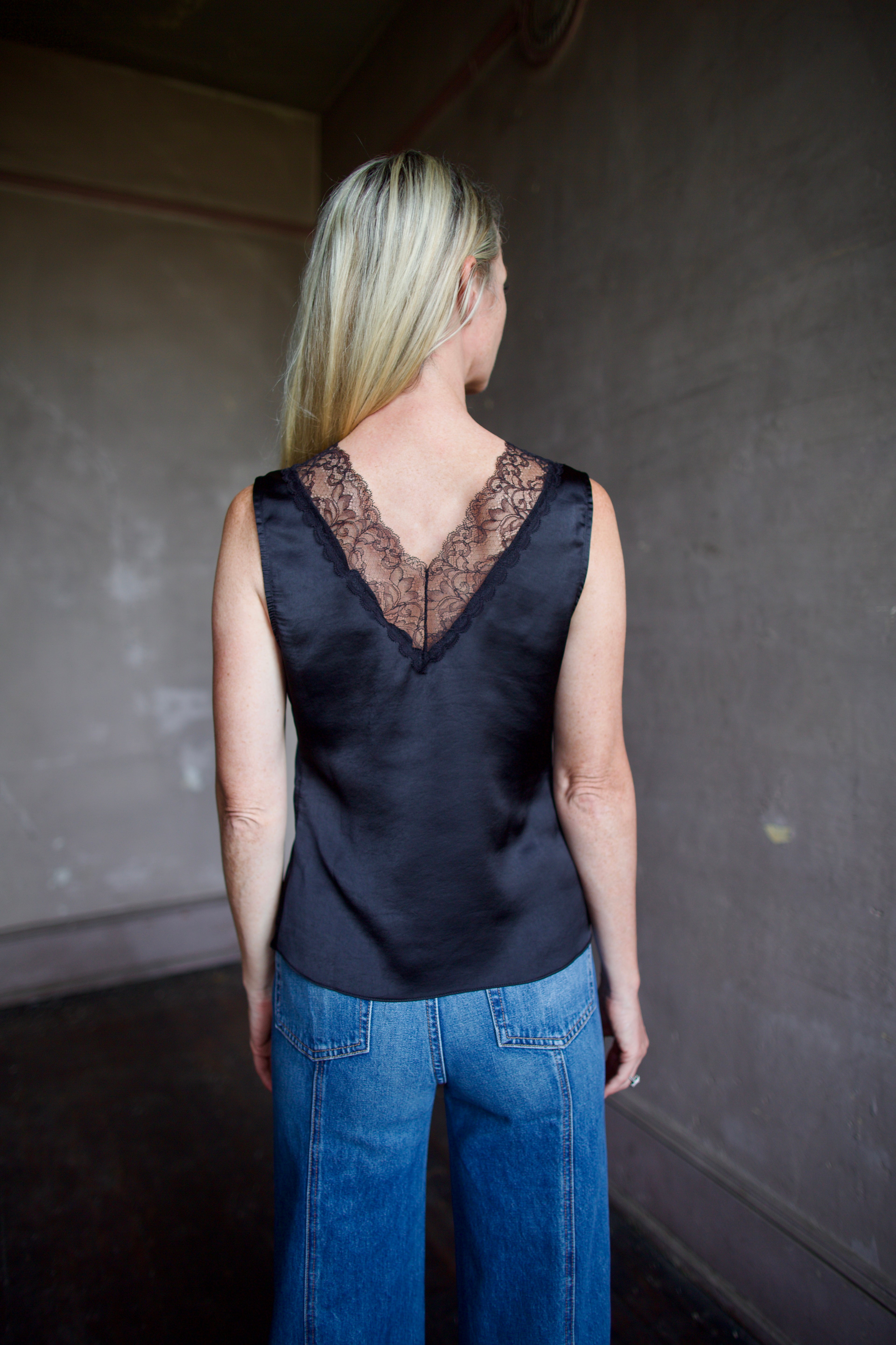 Mature model wearing a bra friendly camisole top with lace detailing at front and back neckline by WE-AR4 