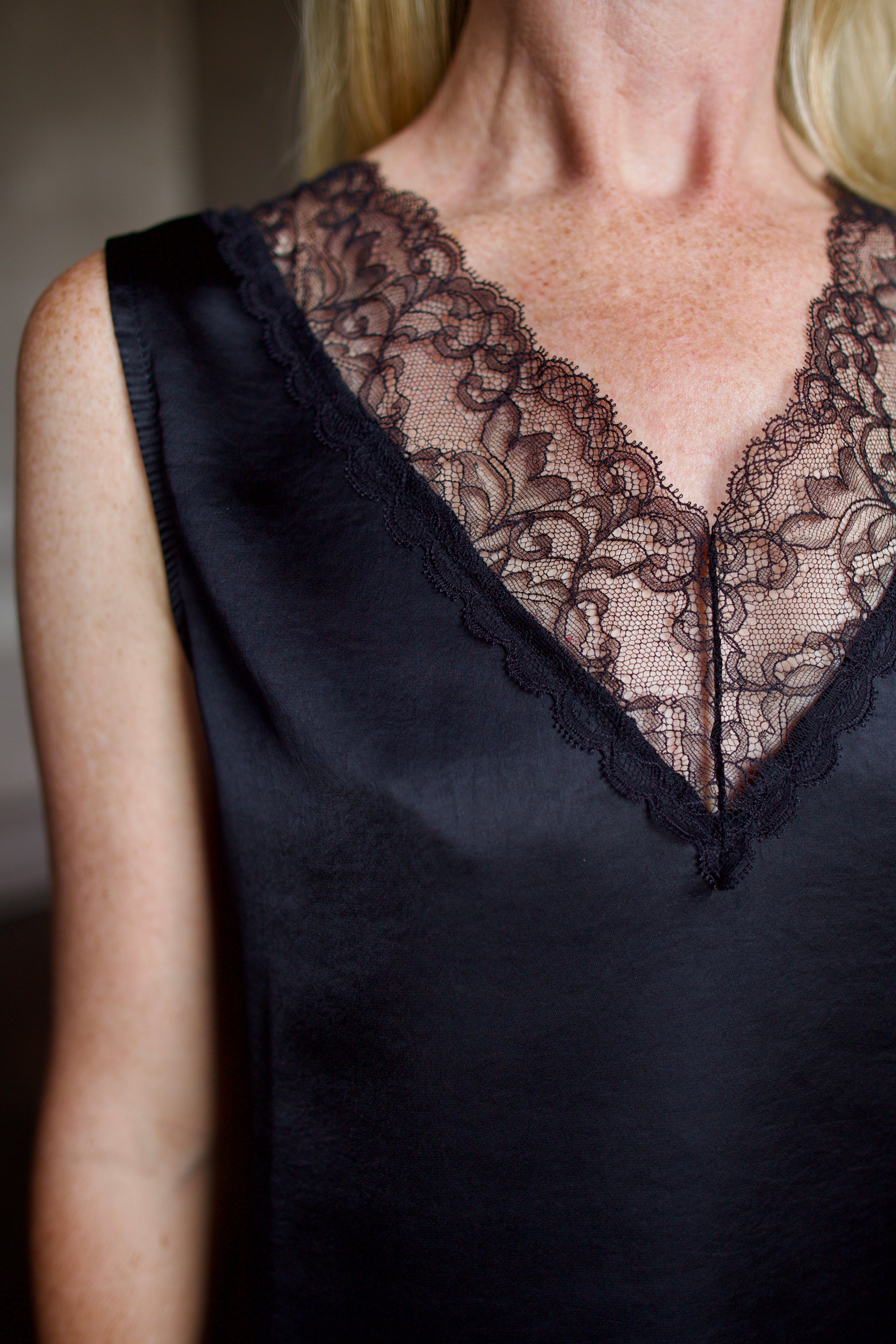 Mature model wearing a bra friendly camisole top with lace detailing at front and back neckline by WE-AR4 