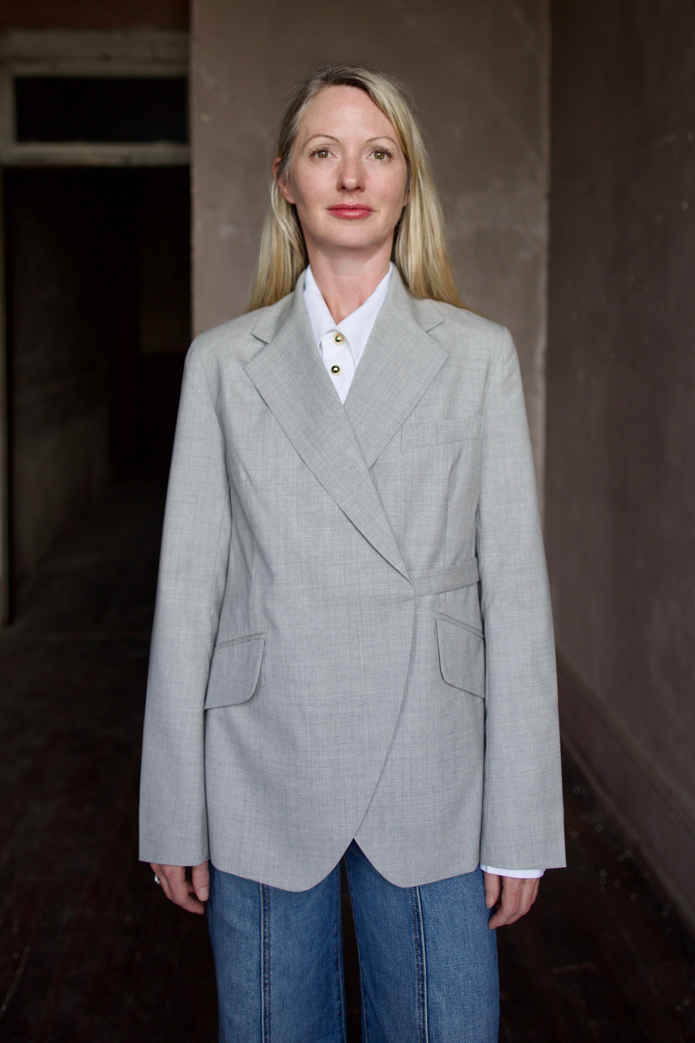 Mature model wearing a WE-AR4 gray wool blazer with luxury detailing and unique modern design