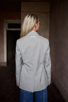 Mature model wearing a WE-AR4 gray wool blazer with luxury detailing and unique modern design