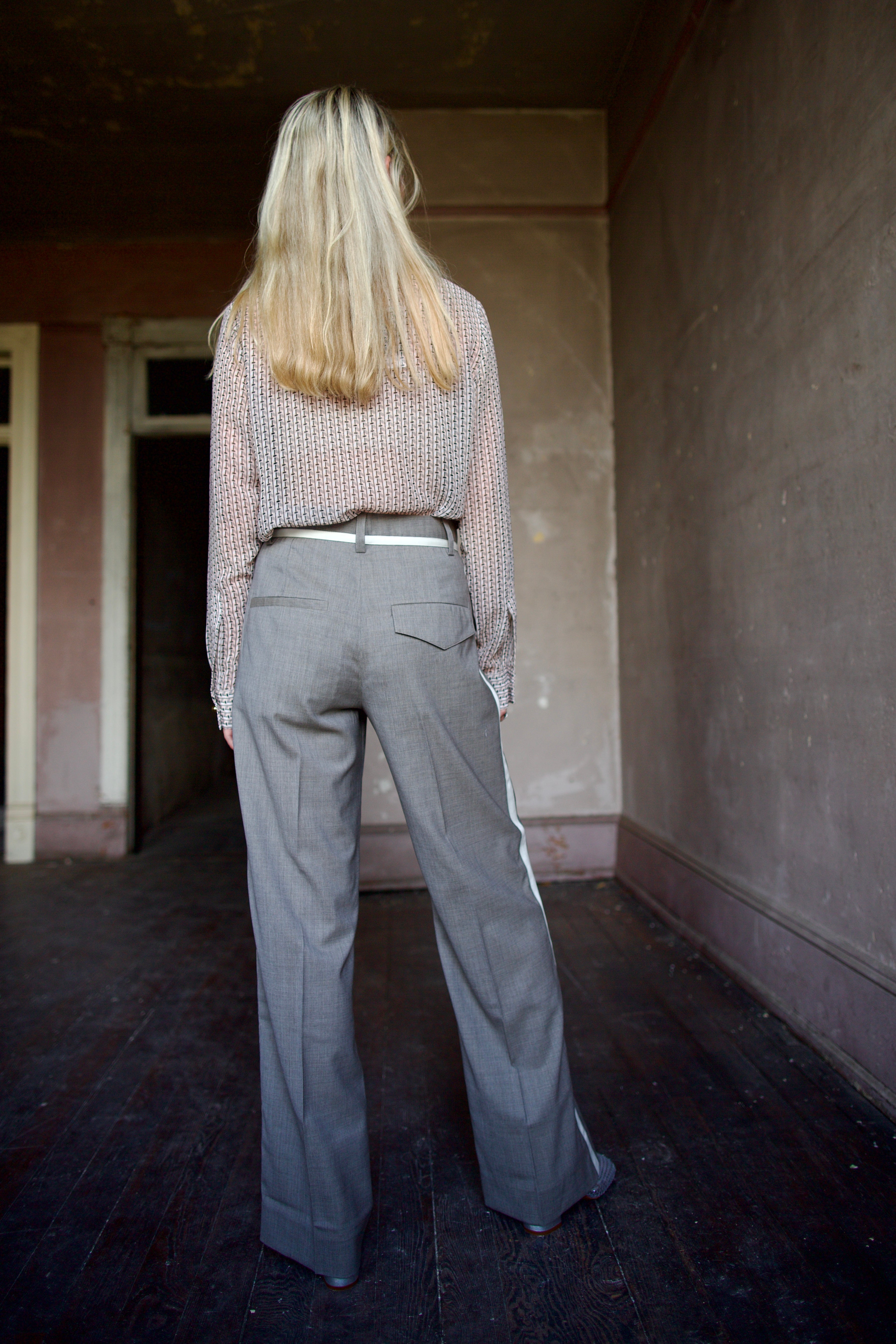 Mature model wearing virgin wool taupe tuxedo trousers with cream details by luxury designer WE-AR4