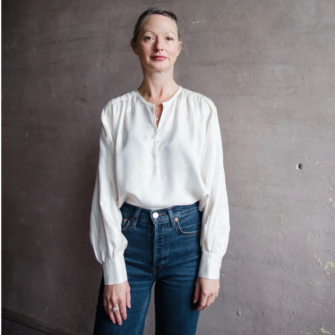 Mature woman wearing Xirena Jacqueline silk ivory blouse with dolman neckline and long sleeves