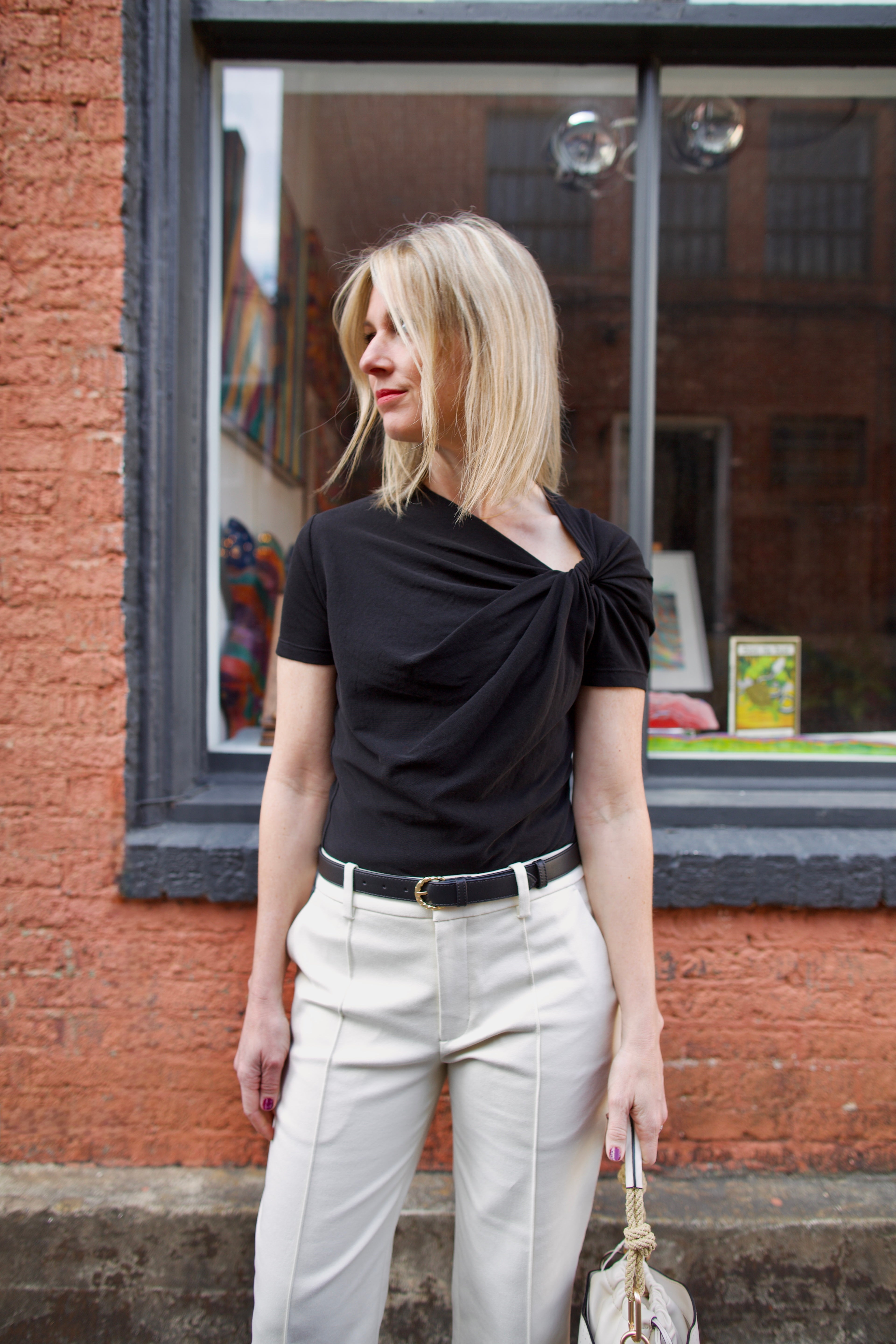 Image of a mature woman wearing the ALC Liz Top, Ulla Johnson Gia Belt and ALC Jay Pants