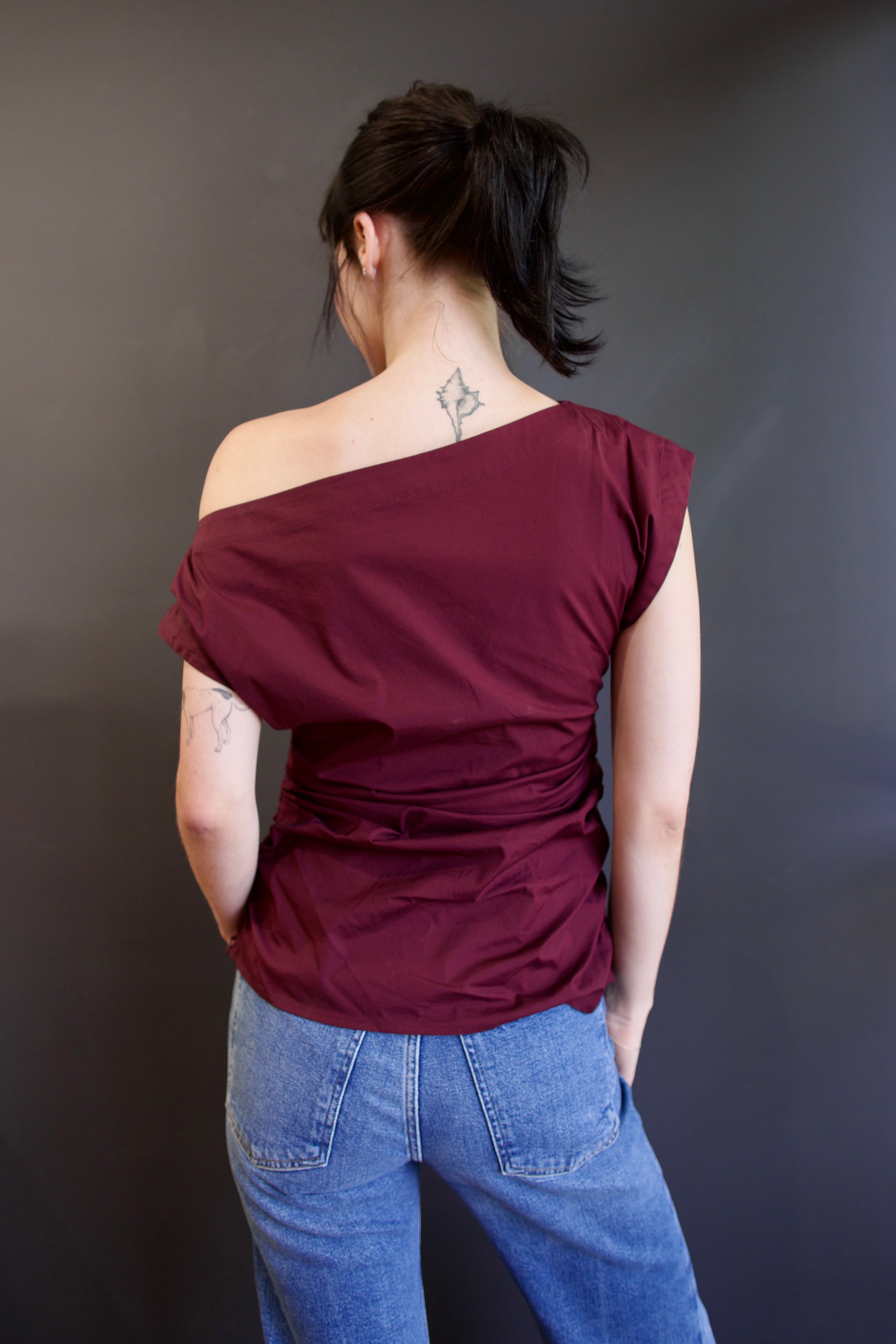 Back of ALC Nara top in burgundy with one-shoulder asymmetrical design and rushing at waistline