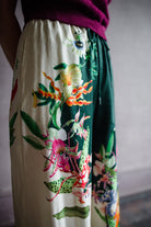 Image featuring a woman wearing the linen blend Aggie pants by Alemais with an elastic waist, wide leg and an allover tropical floral print.