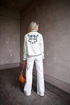 Back image of a woman wearing the Francis Bone Snake Jacket, Le Jean Soft Barrel Jeans, and Ulla Johnson Twyla Bag