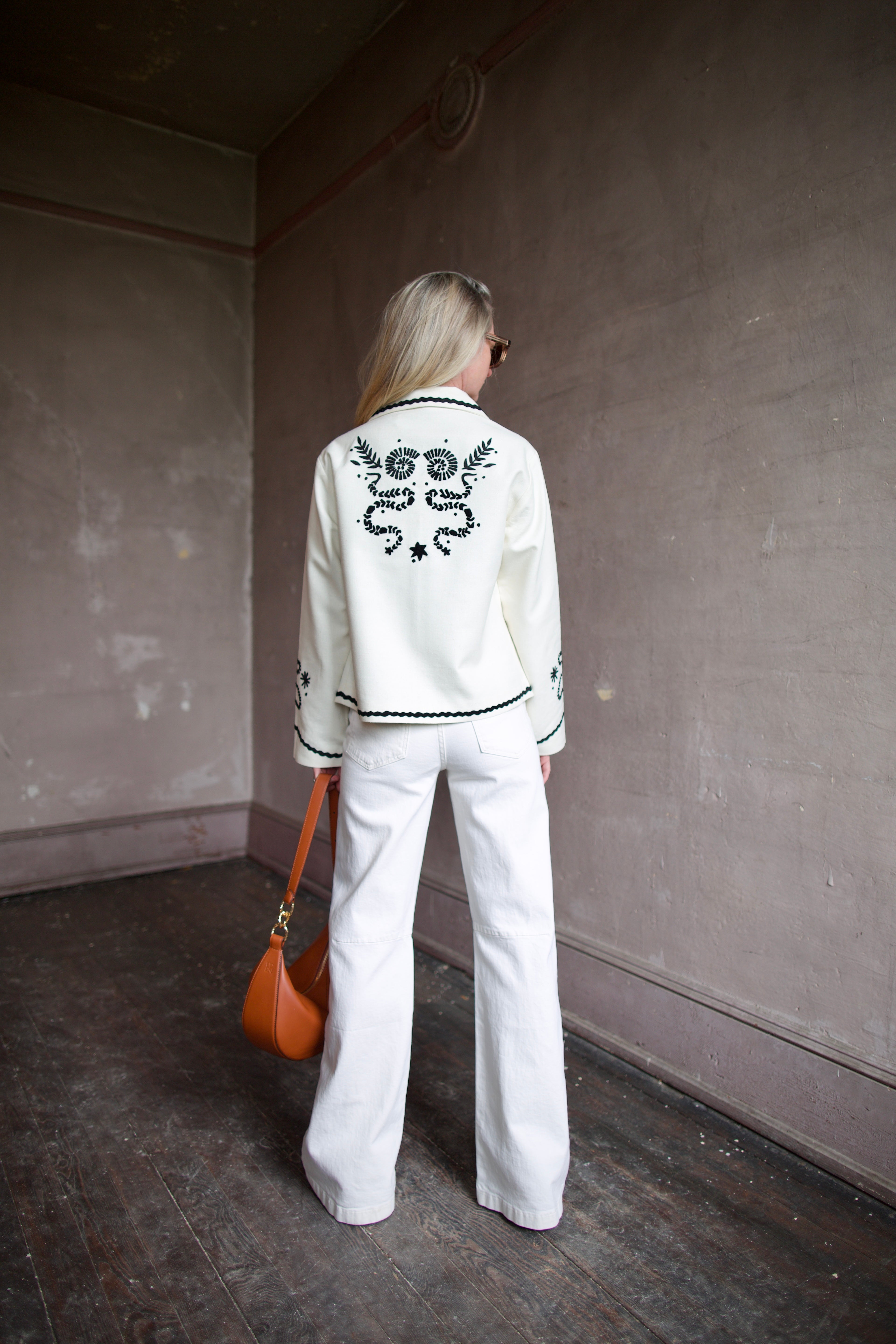 Back image of a woman wearing the Francis Bone Snake Jacket, Le Jean Soft Barrel Jeans, and Ulla Johnson Twyla Bag