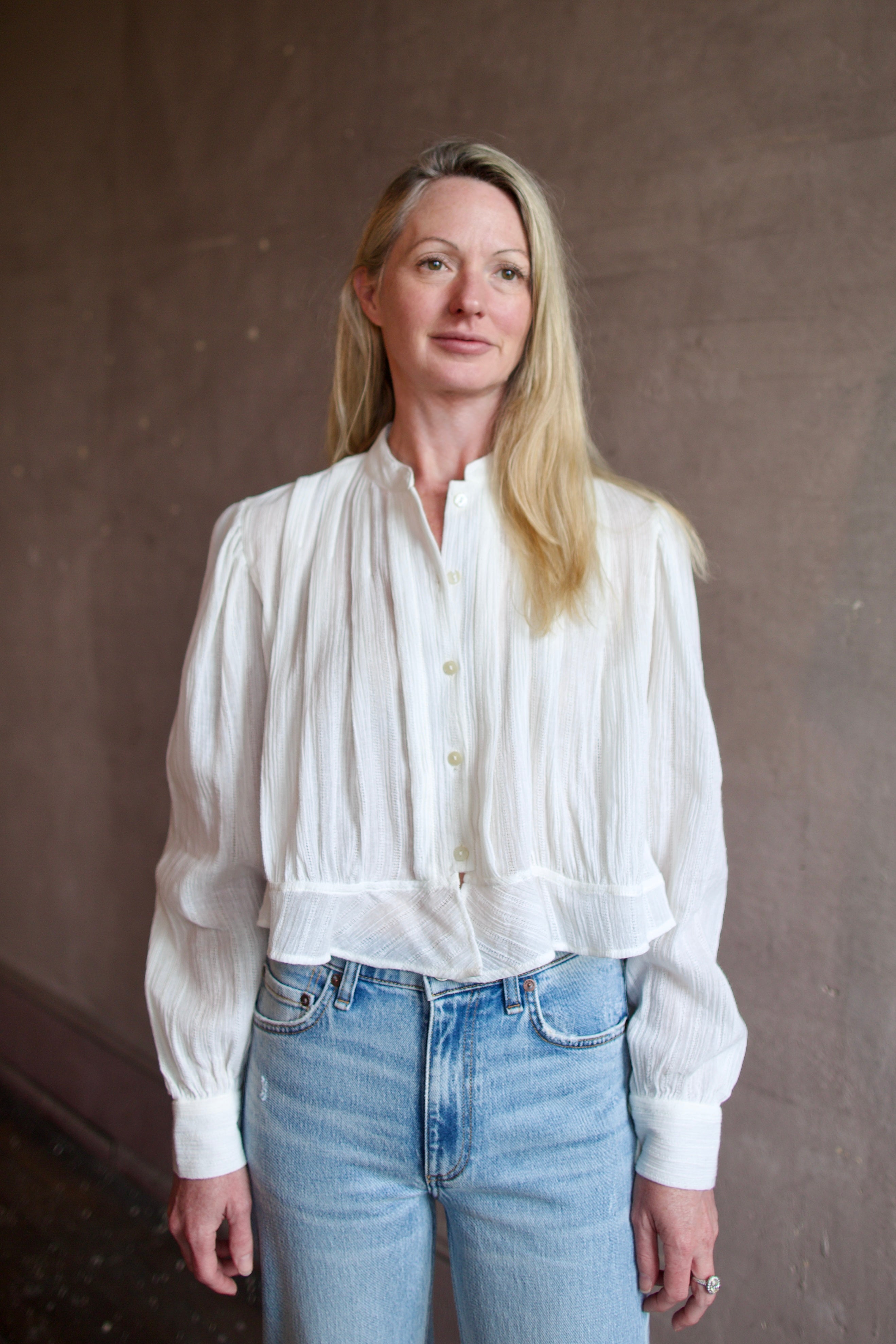 Model wearing the Alix of Bohemia Ryland Pearl Dobby Shirt with elegant pleating details in a comfortable white cotton construction