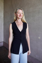 Mature woman wearing a flattering Apiece Apart Marca Knit Top in black with 3 button closure, v- neck and sleeveless