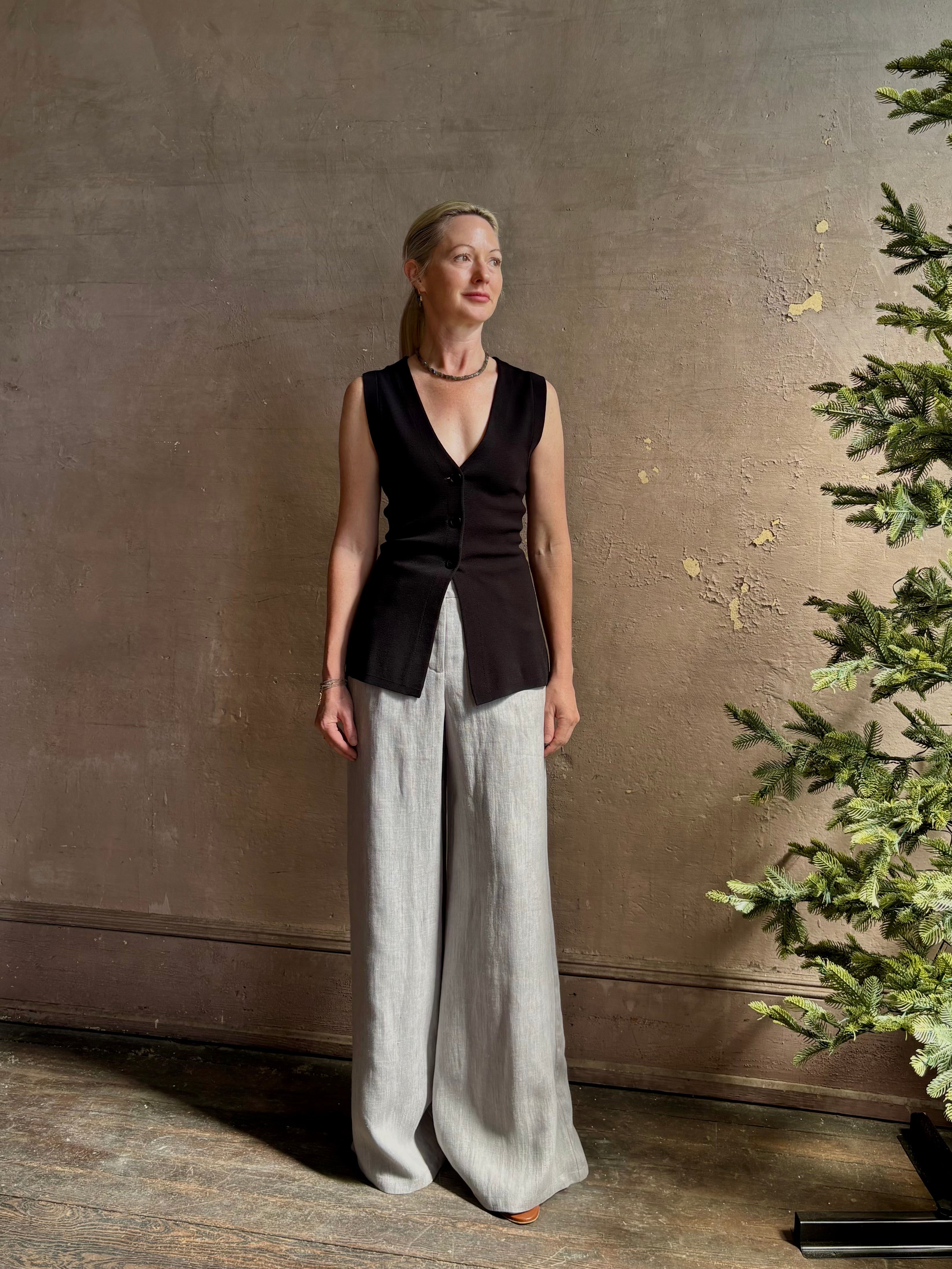 Mature woman wearing a flattering Apiece Apart Marca Knit Top in black with 3 button closure, v- neck and sleeveless
