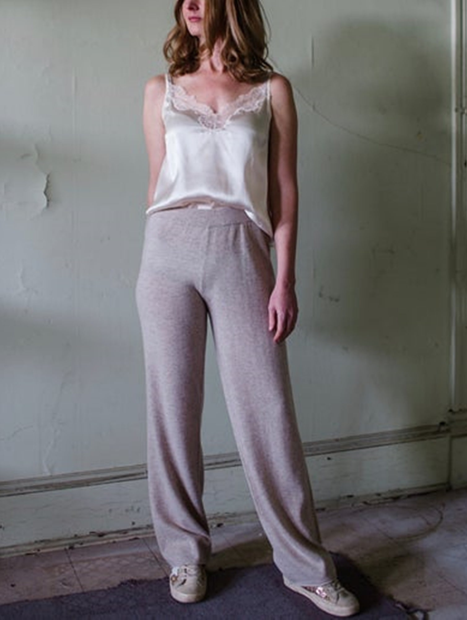 Image featuring a woman wearing the cashmere lounge pants by Kinross with a mid rise and straight leg and a relaxed fit in Mushroom colorway.