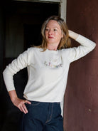 Image featuring a woman wearing the cream cashmere sweater by Lingua Franca with a crew neckline and "I can but I won't" embroidered on the front.