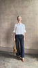 Mature woman reviewing the Next Ex Top from TWP rendered in a crisp white and crafted from premium linen in New York City, this luxury linen top offers effortless cool girl with an intentionally oversized boxy silhouette with tailored half sleeve cuffs, collared button - down menswear inspired with a single front pocket
