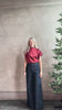 Mature woman wearing ULLA JOHNSON Bianca dark wash tigris rigid denim with a flat front, contrasting front seam details, high rise, wide leg, and side seam concealed zipper closure