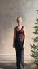 Mature woman reviewing designer denim Colette Straight Leg Jean from Ulla Johnson offering American-made craftsmanship to a clean, timeless, and thoroughly modern everyday silhouette rendered in a sophisticated dark wash and crafted from 100% cotton with twisted buckle detail at waistband