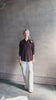 Mature woman reviewing elevated casual wear button front Fonda top by SPRWMN in chocolate brown cashmere with long sleeves and a collar