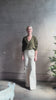 Mature woman wearing luxury Cashmere Silk Marion V-Neck designer Sweater by Rachel Comey in olive green with long sleeves and linear weave