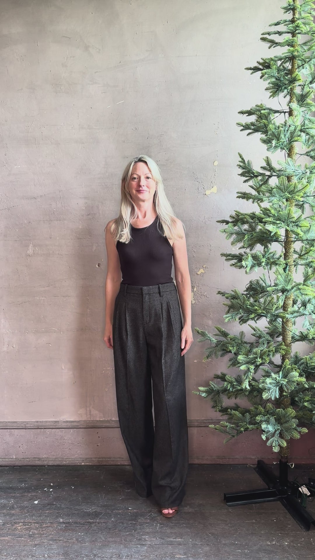 Mature woman reviewing elevated ALC black and tan trouser with zip closure pleated front tailored waistband full length