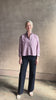 Mature woman reviewing JD blue and white stripe collared button-down shirt by TWP with sequin embellishments