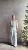 Mature woman reviewing the Orly blouse from Trovata rendered in a charming coastal inspired floral print and crafted from cotton with three quarter sleeves and ruffle lined v-neck