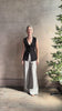 Mature woman reviewing a flattering Apiece Apart Marca Knit Top in black with 3 button closure, v- neck and sleeveless