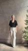 Mature woman reviewing V Neck Tee from SPRWMN rendered in a timeless black and crafted from 100% premium sheer wool with fluid draping and short sleeve