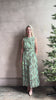 Mature woman reviewing  women's designer celestina silk maxi dress rendered in a mint green ground adorned with delicate brown and pink florals from Ulla Johnson that is sleevesless with gathered fabric bodice and waistband