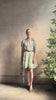 Mature woman reviewing the short Phoebe Dress from Trovata rendered in a charming coastal inspired floral print and crafted from cotton with button front, ruffle lined short sleeves and v-neck
