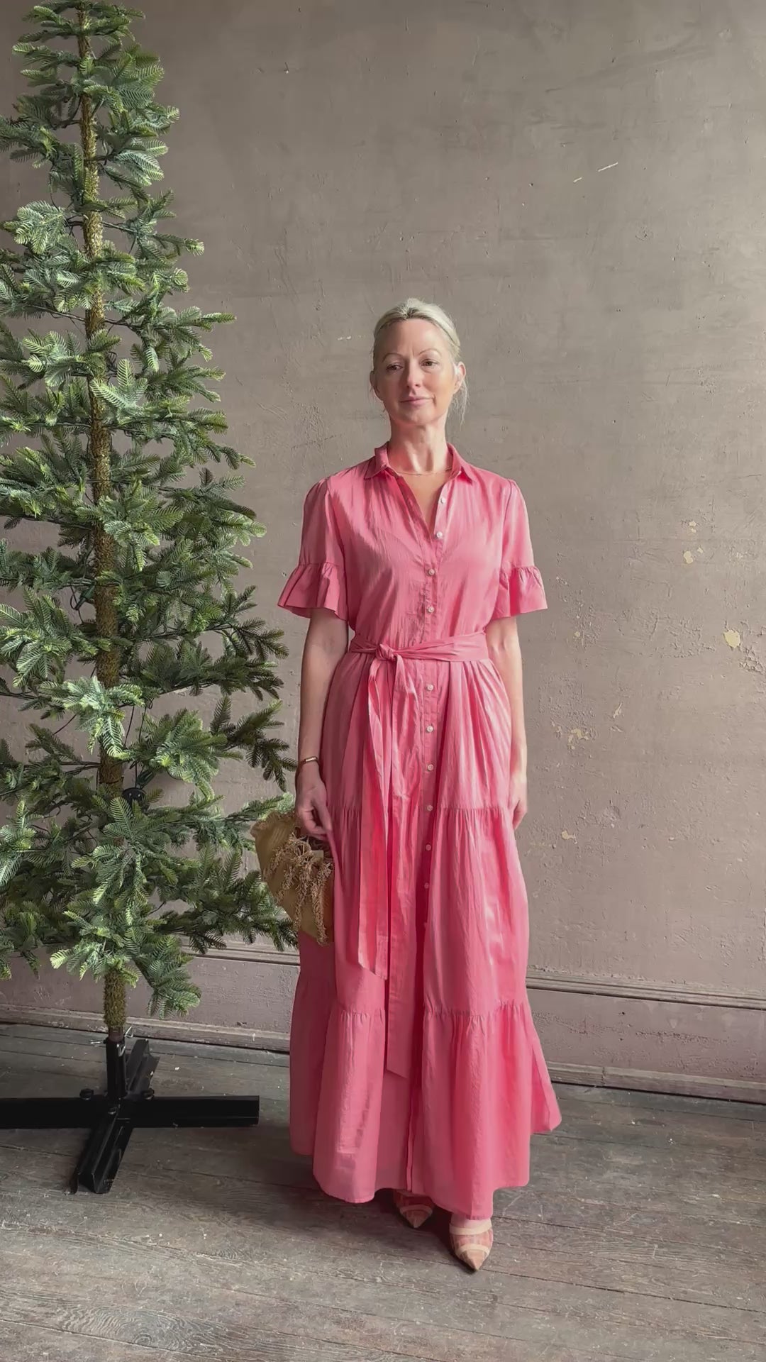 Mature woman reviewing TROVATA Martine button down cotton shirt dress in Rosdo rose with feminine ruffle sleeves and tiered skirt
