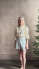 Mature woman reviewing elevated Craig Short from Veronica Beard a sophisticated women's designer short rendered in river mist light blue and crafted from a refined blend of cotton and viscose with side pockets, one front pleat and tailored waistband with belt loops