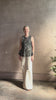 Mature woman reviewing the Ulla Johnson Ali Sleeveless black cotton peplum top with contrast white embroidery for ultimate feminine sophistication