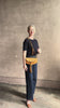 Mature woman reviewing the luxury Italian leather  Paloma handbag with Tassel Flap from Ulla Johnson rendered in a rich caramel brown featuring a pull tassel magnetic snap closure and removable adjustable handle that seamlessly converts to a designer clutch