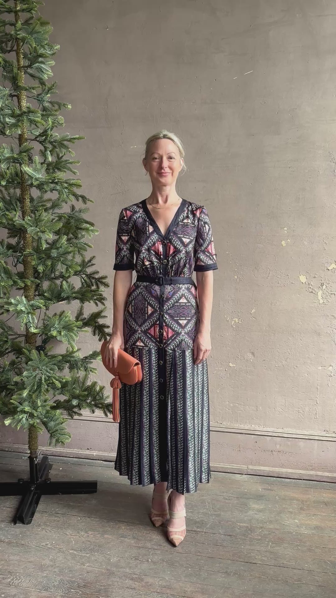 Mature woman reviewing timeless Saloni Lea drop waist button front dress in ikat compass print and pleated skirt wit v-neck and short sleeves