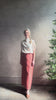 Mature woman reviewing premium wool silk  women's designer Rachel Comey Cosa maxi Skirt with tailored waistband, belt loops and back vent rendered in a vibrant warm pink hue