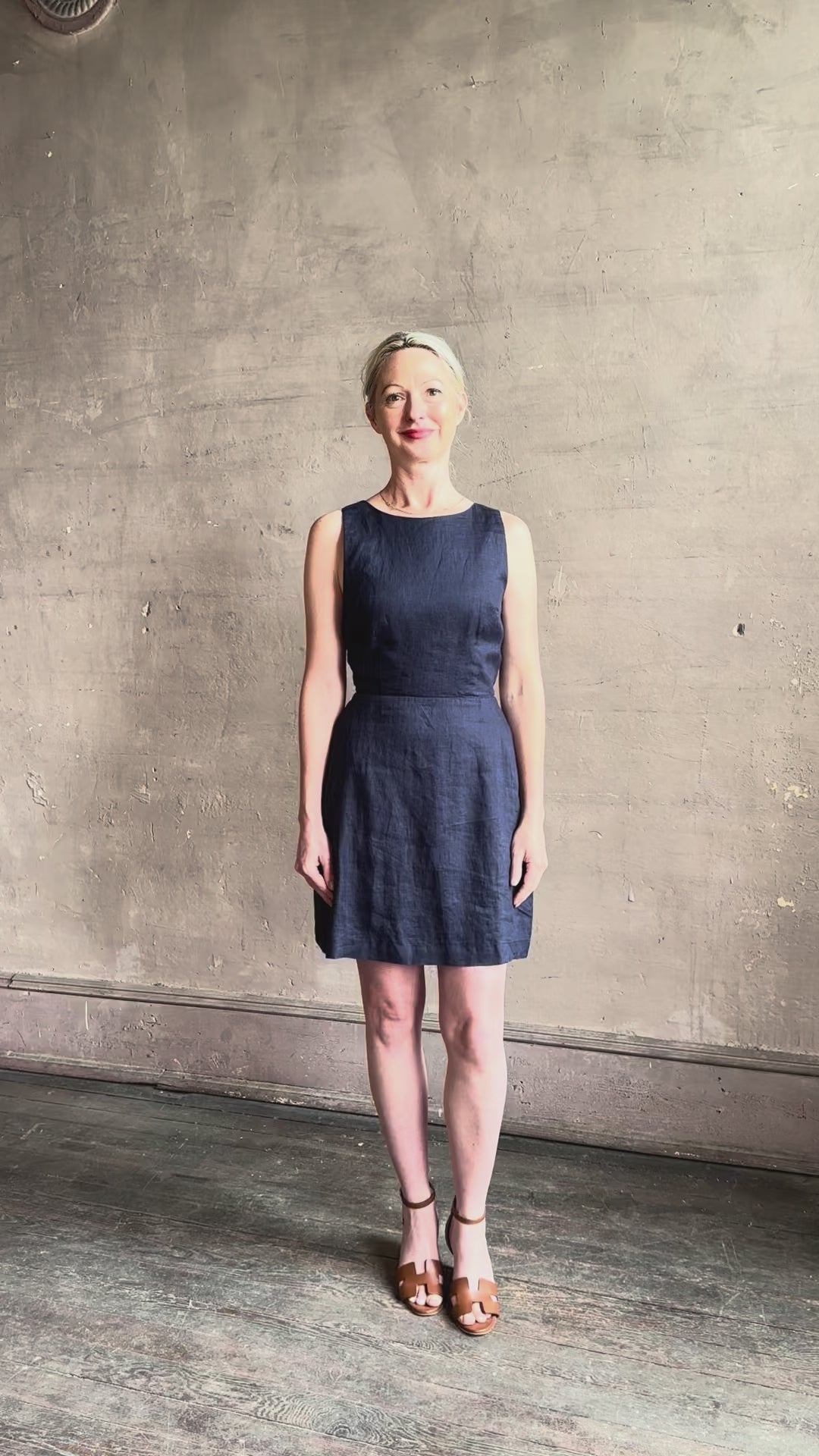Mature woman reviewing the effortless summer dress by Trovata Rosalie linen Dress in Navy Blue with A-line skirt and sophisticated bra friendly open back