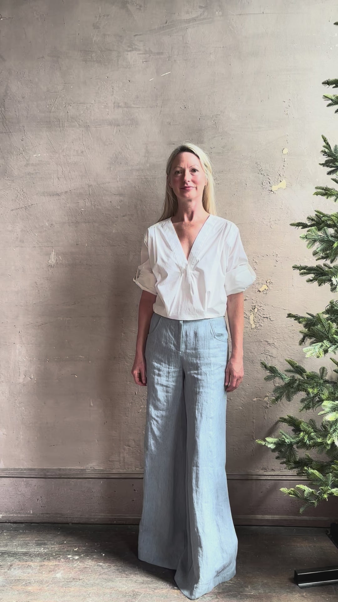 Mature woman reviewing The A.L.C. Jordan Top in White Long sleeve blouse boasts premium cotton blend with v-neck and tab to roll sleeves up to a half sleeve