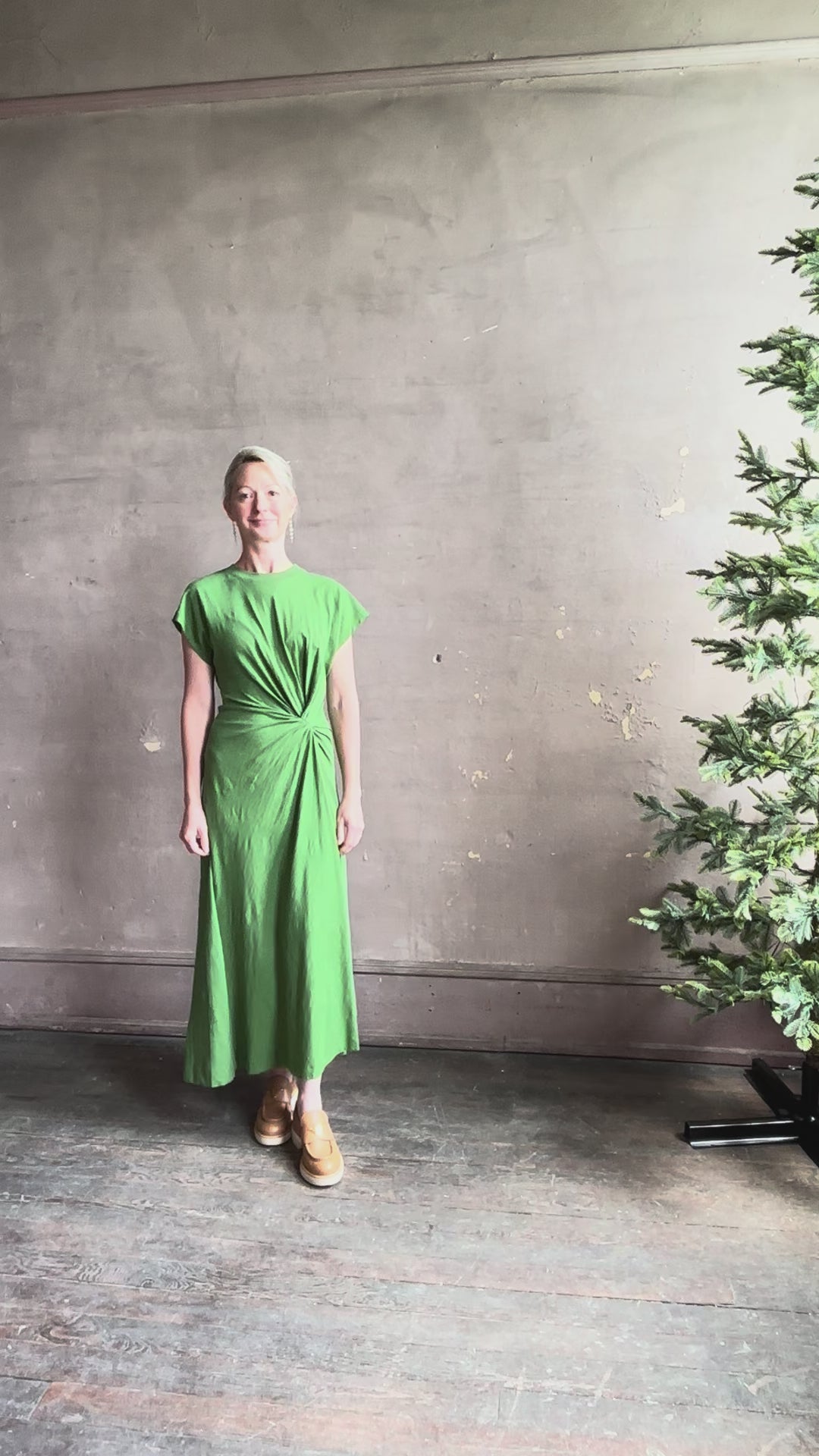 Mature woman reviewing Volta Twist maxi Dress from Apiece Apart in a comfy green organic cotton jersey with short sleeves and crew neck