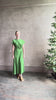 Mature woman reviewing Volta Twist maxi Dress from Apiece Apart in a comfy green organic cotton jersey with short sleeves and crew neck