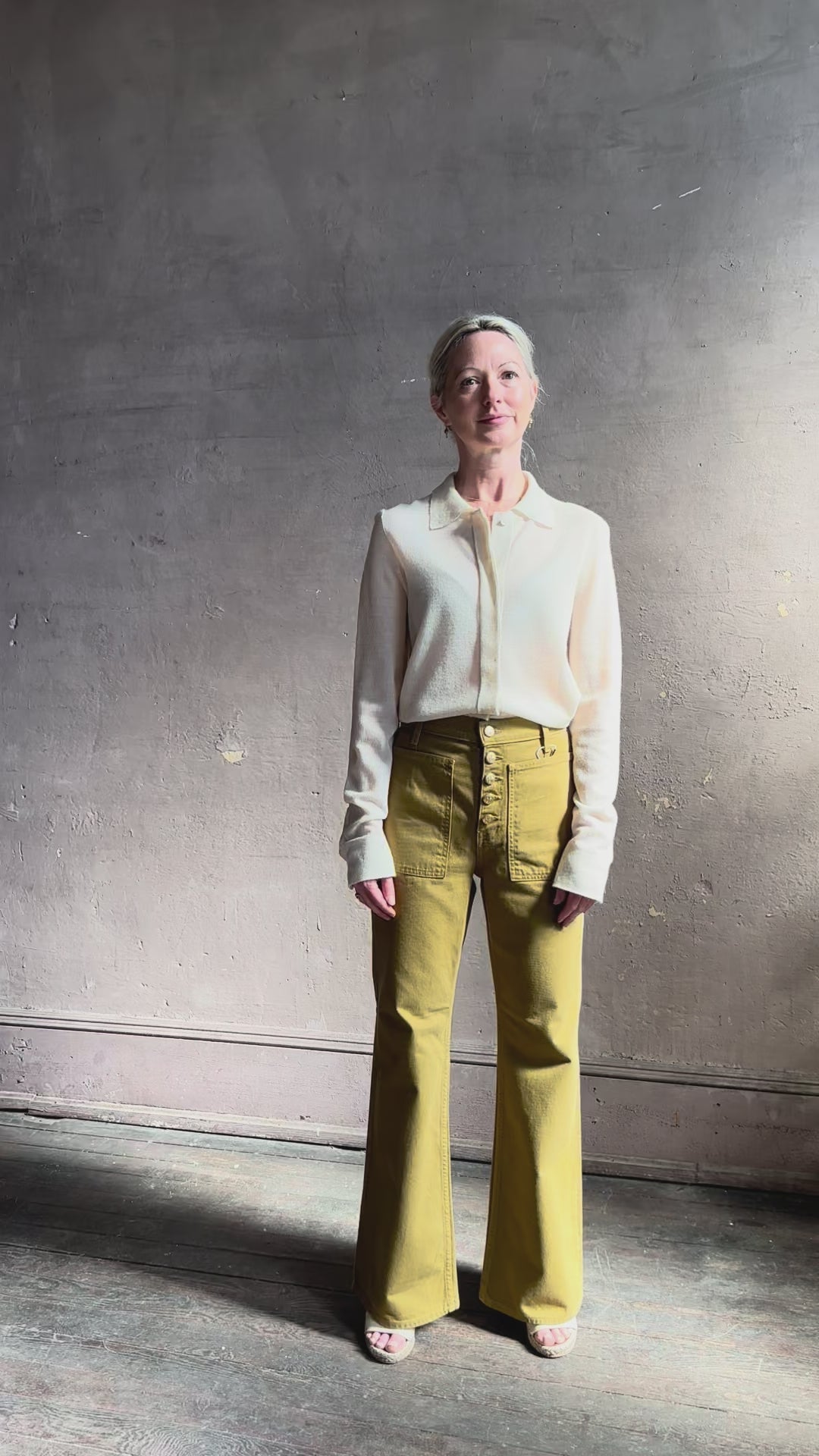Mature woman reviewing Premium Baby Alpaca Mulberry Silk Calma shirt by Rachel Comey with button front, long sleeves and collar rendered in cream