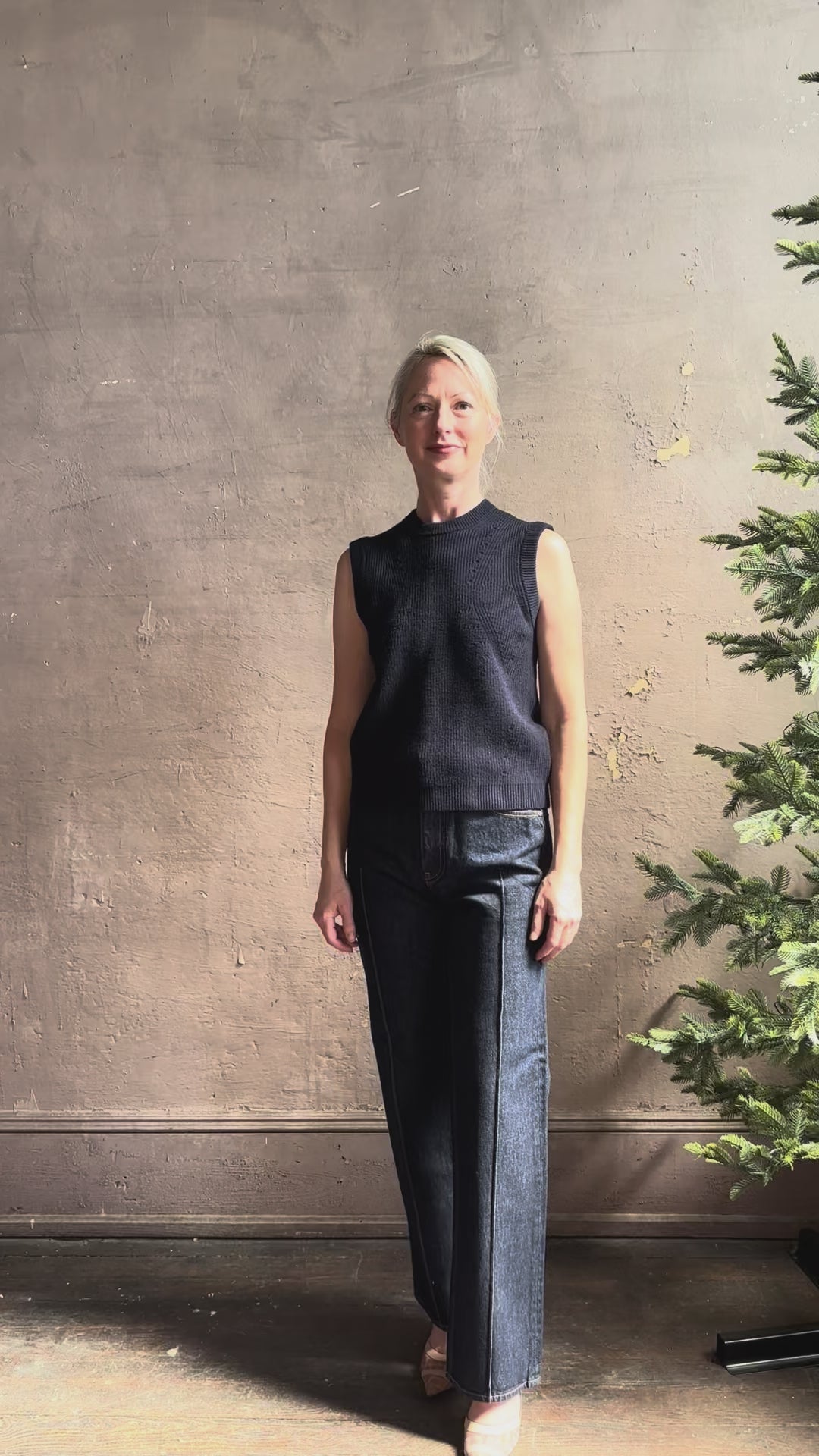 Mature woman reviewing designer Margot sleeveless Knit Top from Ulla Johnson rendered in a rich midnight blue and knitted from 100% cotton with refined design details and a crew neckline for everyday sophistication