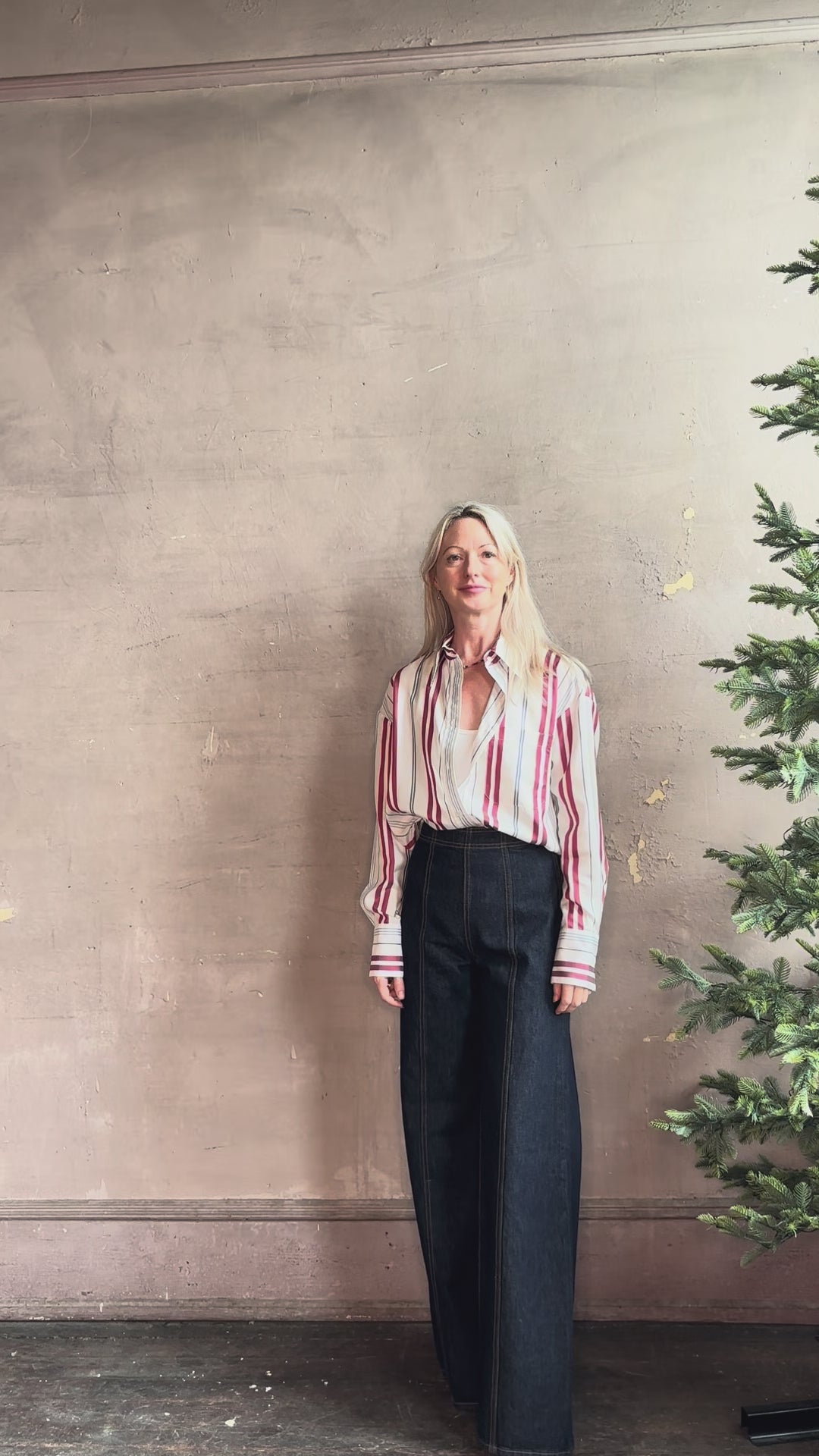 Mature woman reviewing Big Joe Shirt from TWP rendered in an ivory, blue, and wine striped colorway and crafted from silk in the USA with collar, button front and wide cuffed long sleeves in a generous oversized fit