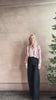 Mature woman reviewing Big Joe Shirt from TWP rendered in an ivory, blue, and wine striped colorway and crafted from silk in the USA with collar, button front and wide cuffed long sleeves in a generous oversized fit