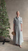 Mature woman reviewing luxury Jenny's Gown from designer TWP rendered in a lumines white and blue stripe print and crafted in USA from a viscose and lorex blend this lightweight long sleeve maxi  dress drapes beautifully with a flowing quality that moves with understated grace 