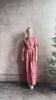 Mature woman reviewing Martine maxi Dress from Trovata rendered in the Botanic Tile pink and orange floral print and crafted from a luxurious blend of cotton and silk with button front, collar, short sleeves and matching optional self tile belt