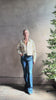 Mature woman reviewing designer ULLA JOHNSON Bobbi cotton denim Jacket in an artisan collaboration print Infinite Flower with gold buttons, front pockets and crop length cool girl vibe